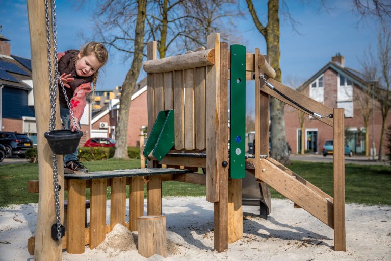 Meisje speelt op een klimrek in een speeltuin